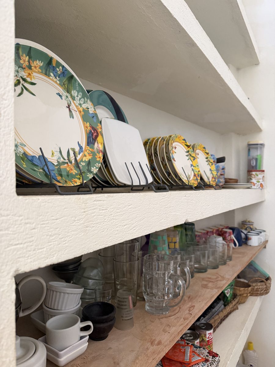 Vajilla de colores y vasos en los estantes abiertos de la cocina